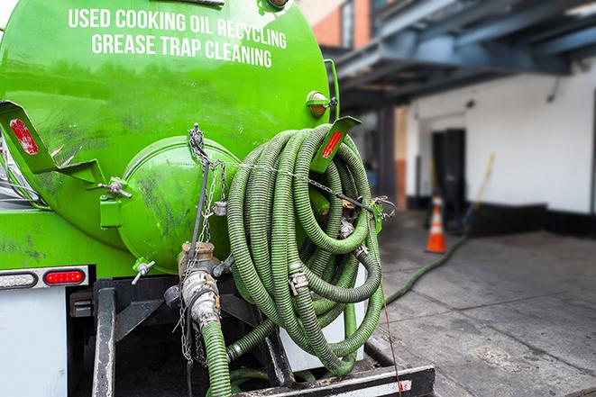 grease trap being pumped out by service technician in Churchville